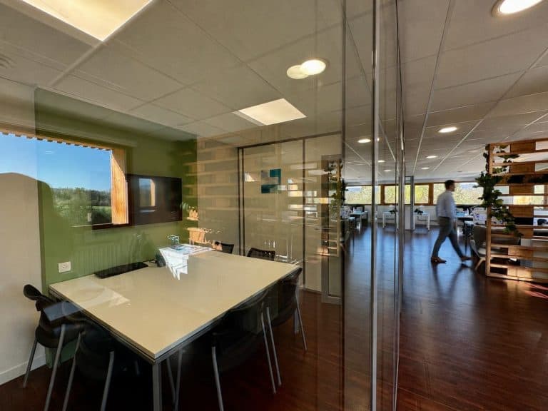 Salle de réunion vitrée de l’agence du Groupe AXITE à Annecy, ouverte sur le plateau
