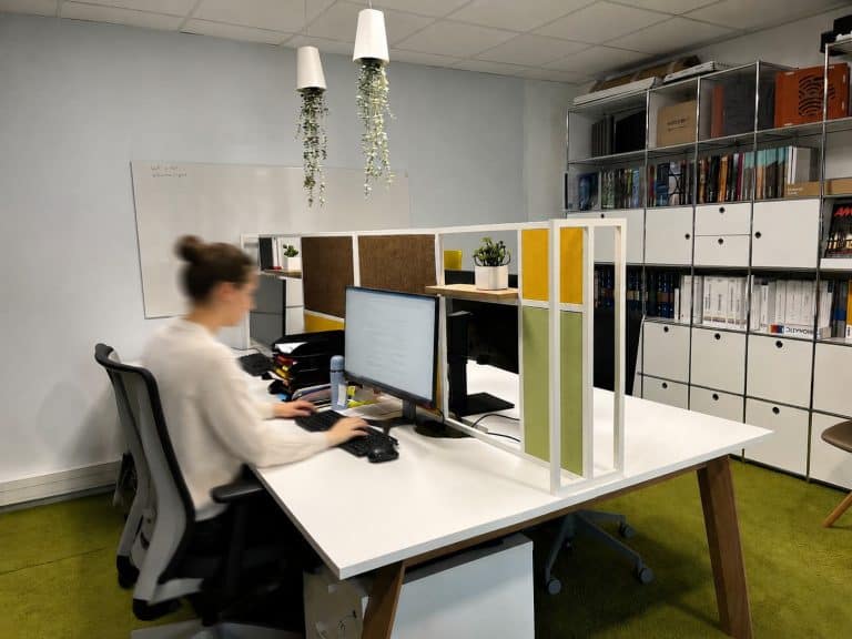 Poste de travail de l’agence du Groupe AXITE à Bourgoin-Jallieu, entre séparateurs en feutre vert et jaune