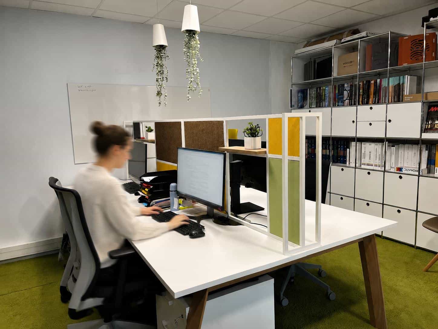 Poste de travail de l’agence du Groupe AXITE à Bourgoin-Jallieu, entre séparateurs en feutre vert et jaune