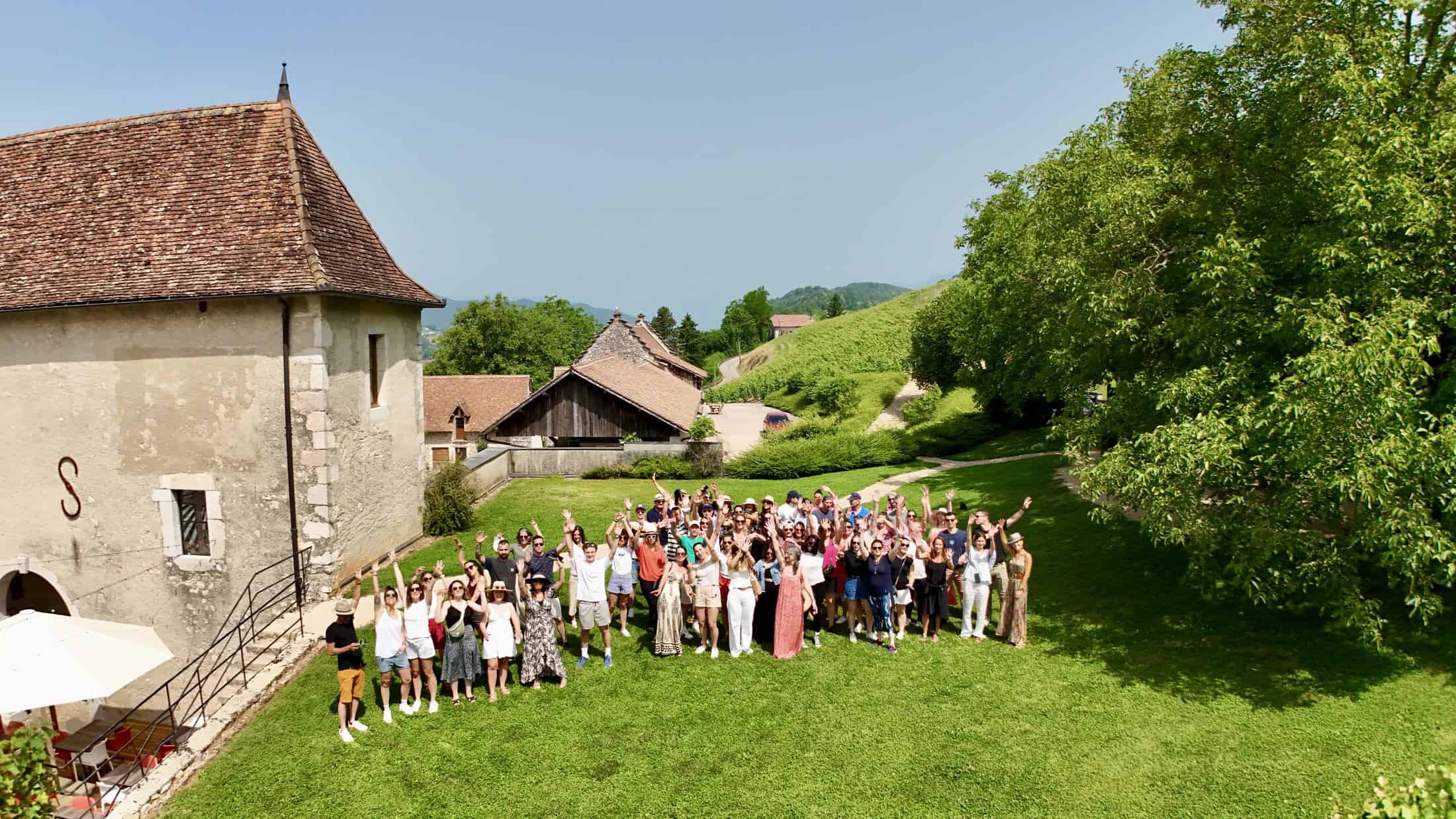 Les équipes du Groupe AXITE réunies en plein air, bras levés