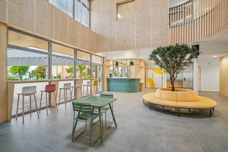 Hall de L’Esquisse, tiers-lieu de Grésy-sur-Aix meublé par WOM : banquette ronde autour d’un olivier