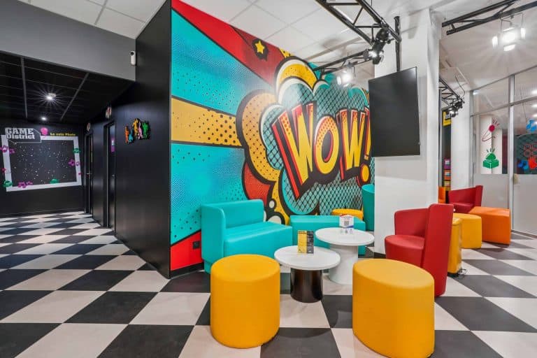 Salon de Game District à Chambéry meublé par WOM : fresque pop, fauteuils et poufs colorés