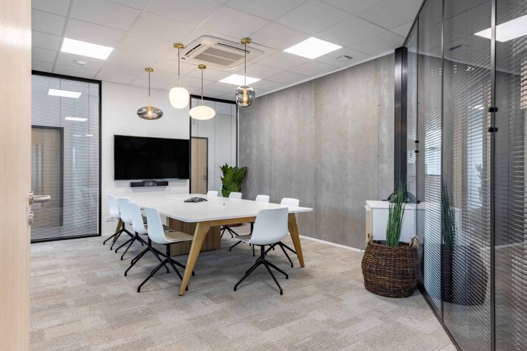Salle de réunion de Novances à Archamps, équipée par WOM : écran et table en bois clair