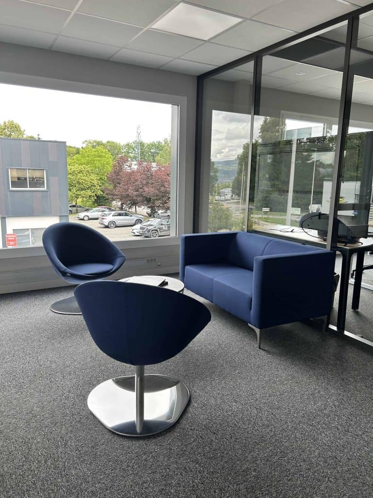 Coin d’attente meublé par WOM chez la Société Savoisienne des Métaux à Annecy : canapé et fauteuils bleus